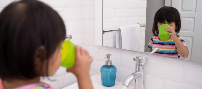 Child Drinking Water at Bathroom Sink